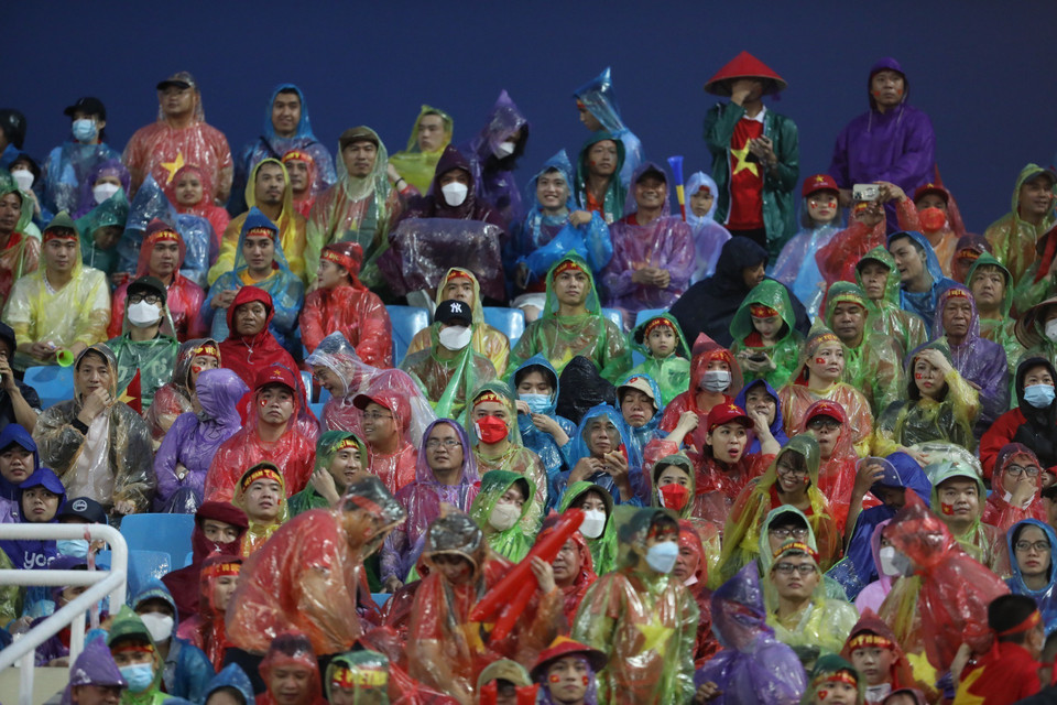 Cổ động viên Việt Nam đội mưa đến sân vận động Mỹ Đình để cổ vũ cho U23 thi đấu. (Ảnh: Minh Quyết/TTXVN)