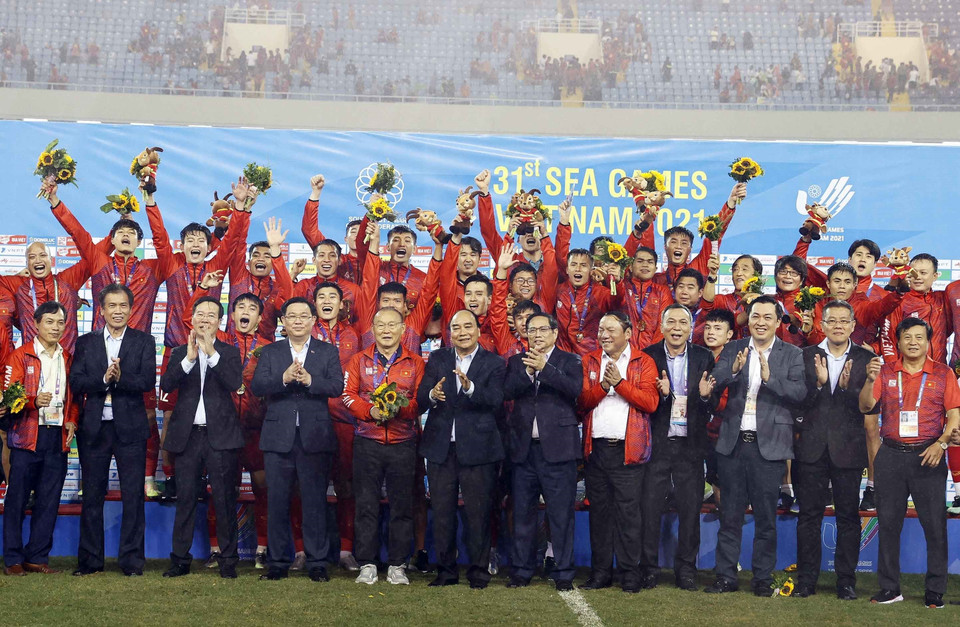 Chủ tịch nước Nguyễn Xuân Phúc, Thủ tướng Phạm Minh Chính, Chủ tịch Quốc hội Vương Đình Huệ, Thường trực Ban Bí thư Võ Văn Thưởng và các đại biểu chụp ảnh chung với Đội tuyển bóng đá U23 Việt Nam vừa giành huy chương Vàng môn bóng đá nam SEA Games 31. (Ảnh: Thống Nhất/TTXVN)