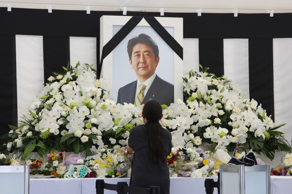 Một người phụ nữ bày tỏ lòng thành kính trước di ảnh của cố Thủ tướng Abe. (Ảnh: Đào Thanh Tùng/TTXVN)