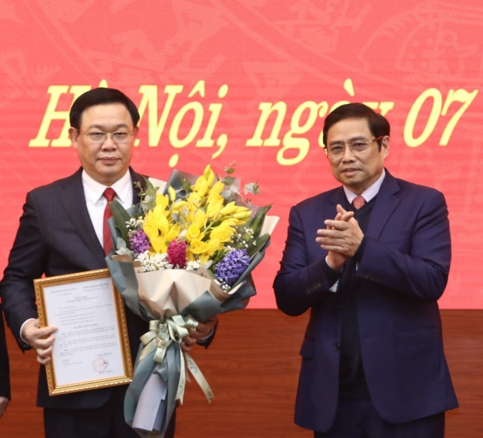 Trưởng Ban Tổ chức Trung ương Phạm Minh Chính tặng hoa, chúc mừng Bí thư Thành ủy Hà Nội Vương Đình Huệ. (Ảnh: Văn Điệp/TTXVN)