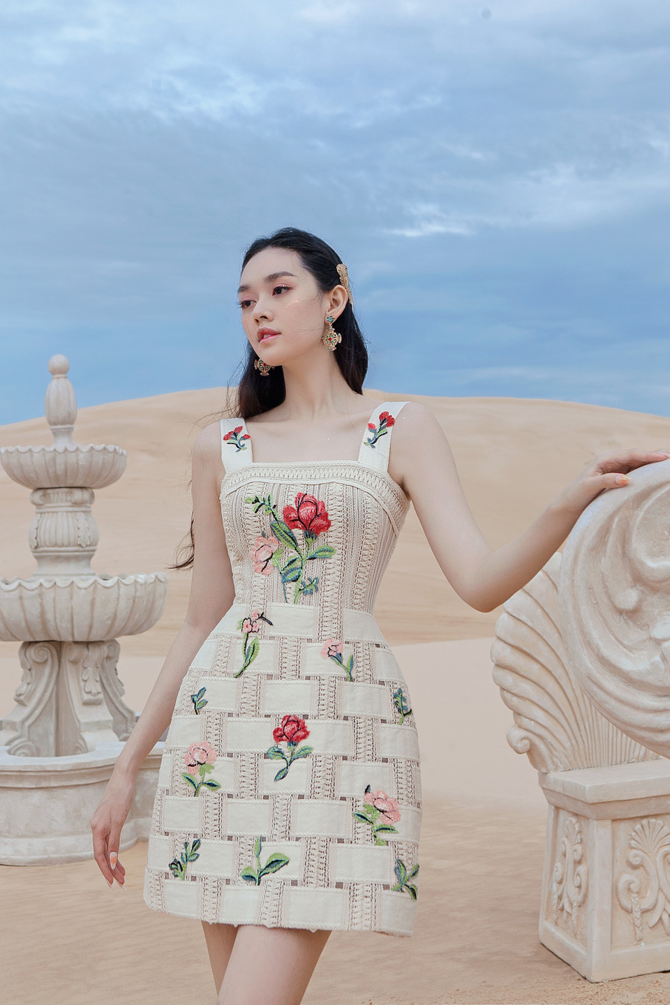 Á hậu cho biết cô gặp không ít khó khăn khi đi giày cao gót đứng trên cát. Tuy nhiên, cô vẫn cố gắng trụ vững, tự tin thả dáng với thần thái quyến rũ, hoàn thành xuất sắc bộ ảnh và thể hiện đúng tinh thần của bộ sưu tập. (Ảnh: CTV/Vietnam+)