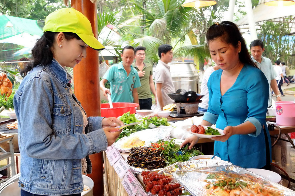 Khách tham quan thưởng thức món ăn tại Liên hoan. (Ảnh: An Hiếu/Vietnam+)