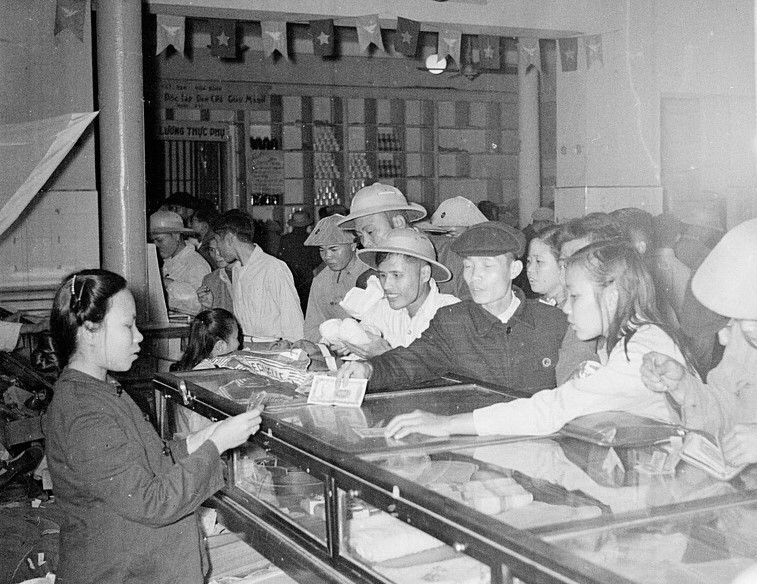 Thực hiện kế hoạch 3 năm lần thứ nhất (1955-1957) và 3 năm lần thứ hai (1958-1960) đã làm diện mạo miền Bắc thay đổi với sự phục hồi, phát triển của nhiều thành phần kinh tế, đời sống nhân dân dần được nâng cao, trong đó thành phần kinh tế toàn dân và tập thể đóng vai trò chủ đạo trong cơ cấu kinh tế quốc dân. Trong ảnh: Cửa hàng mậu dịch phục vụ Tết Bính Thân 1956 tại Hà Nội. (Ảnh: TTXVN)
