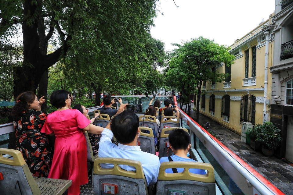 Du khách tham quan Hà Nội bằng xe buýt 2 tầng. (Ảnh: Tuấn Anh/TTXVN)
