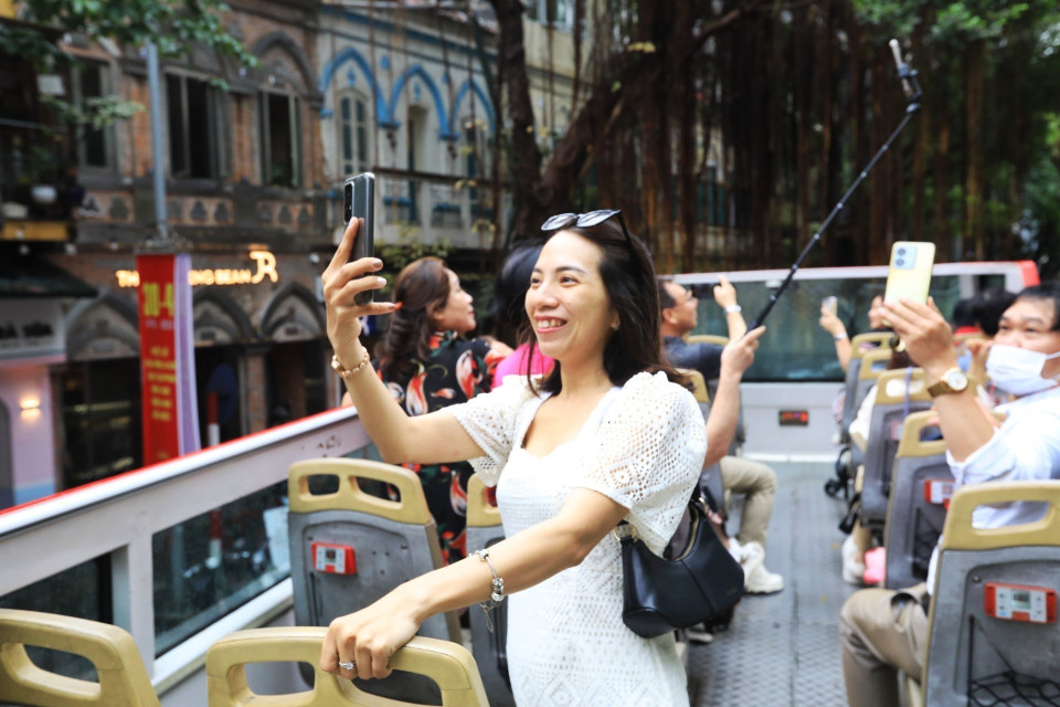 Chị Lê Thị Hồng Vân, du khách đến từ Bình Thuận hào hứng khi được tham quan Hà Nội bằng xe buýt 2 tầng. (Ảnh: Tuấn Anh/TTXVN)