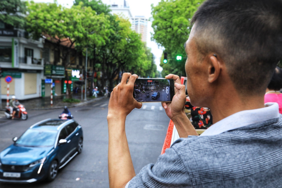 Du khách hào hứng khi được tham quan Hà Nội bằng xe buýt 2 tầng. (Ảnh: Tuấn Anh/TTXVN)