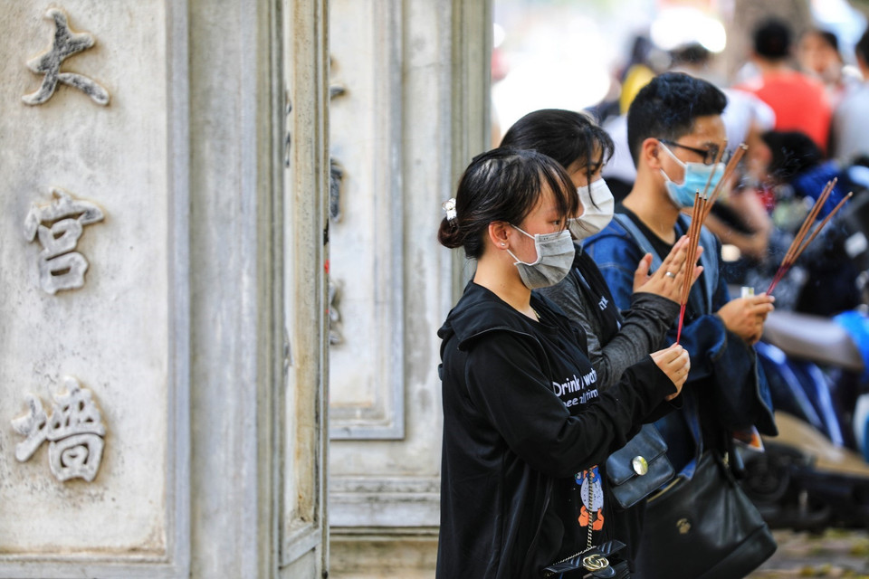 Các điểm di tích chưa mở cửa, phụ huynh và sỹ tử chỉ đặt lễ, dâng hương vái vọng bên ngoài cửa Văn Miếu-Quốc Tử Giám. (Ảnh: Thành Đạt/TTXVN)