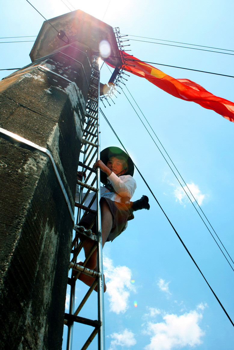 Phóng viên ảnh TTXVN Phạm Thế Duyệt tác nghiệp trong chuyến đi công tác tại Quần đảo Trường Sa. (Ảnh: TTXVN)