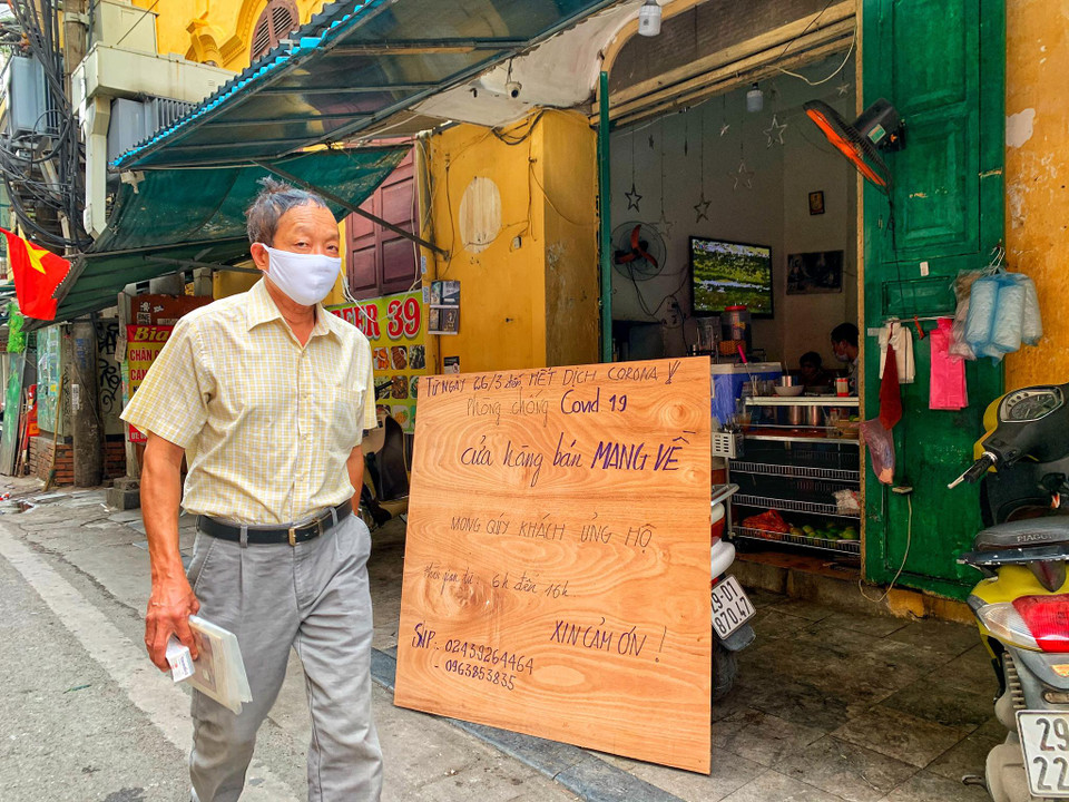 Trên những khu phố cổ vốn đông đúc hàng quán, tấp nập du khách nay chỉ còn lác đác quán phục vụ với thông báo không nhận khách tại chỗ, chỉ 'bán mang về' như thế này. (Ảnh: Mai Mai/Vietnam+)