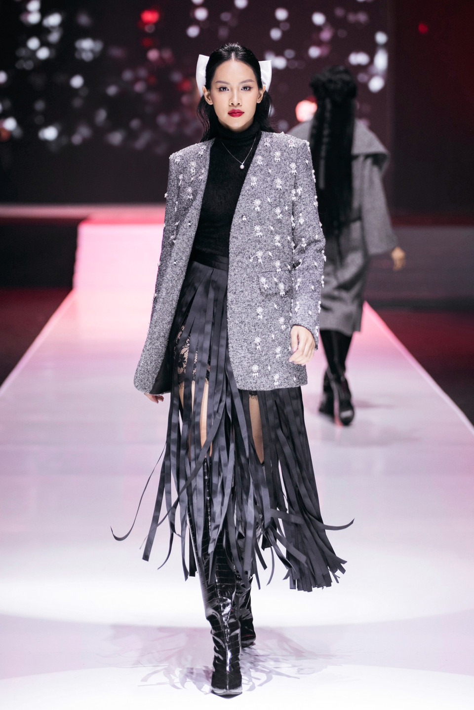 Dàn người mẫu xuất hiện trong loạt thiết kế “lăng xê” mốt tua rua kết hợp với phụ kiện nơ bản to, mang đến những tạo hình đầy ấn tượng. (Ảnh: PV/Vietnam+)