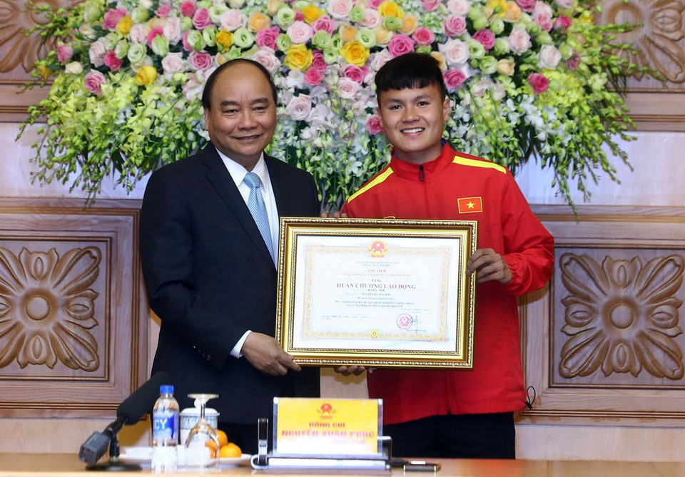 Thủ tướng Nguyễn Xuân Phúc trao tặng Huân chương lao động Hạng Nhì cho cầu thủ Nguyễn Quang Hải. (Ảnh: Thống Nhất/TTXVN)