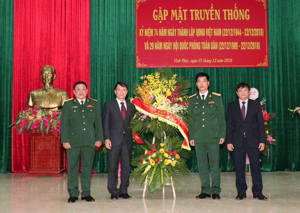 Tổng giám đốc TTXVN Nguyễn Đức Lợi tặng hoa chúc mừng Sư đoàn 304. (Ảnh: Văn Điệp/TTXVN)