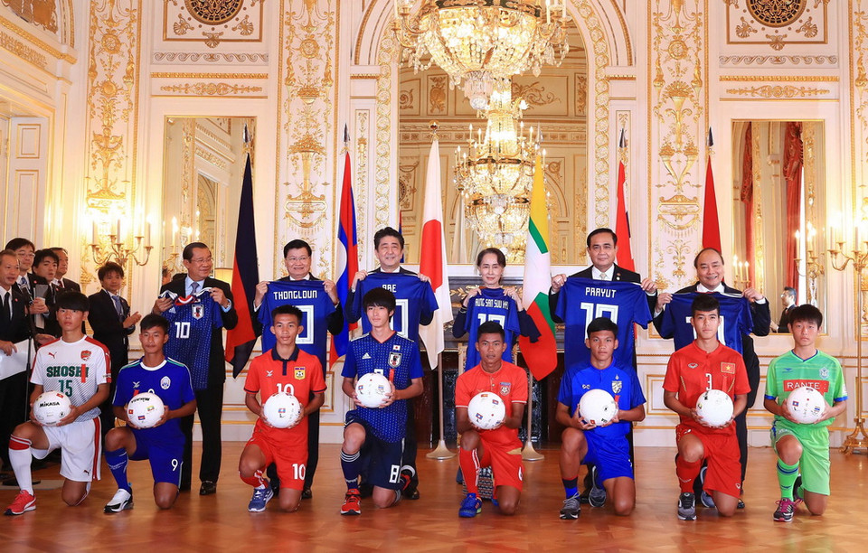Thủ tướng Nguyễn Xuân Phúc, Thủ tướng Thái Lan Prayuth Chan-ocha, Cố vấn Nhà nước Myanmar Aung San Suu Kyi, Thủ tướng Nhật Bản Shinzo Abe, Thủ tướng Lào Thongloun Sisoulith và Thủ tướng Campuchia Samdech Hun Sen và các đại biểu chụp ảnh chung với các đội trưởng đội tuyển bóng đá U17 Mekong và Nhật Bản. (Ảnh: Thống Nhất/TTXVN)