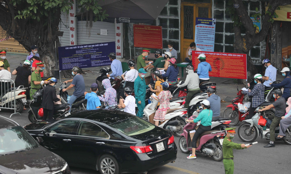 Kiểm tra giấy tờ, thông tin của người lưu thông qua chốt kiểm soát phòng chống dịch trên phố Lò Đúc (quận Hai Bà Trưng). (Ảnh: Thanh Tùng/TTXVN)