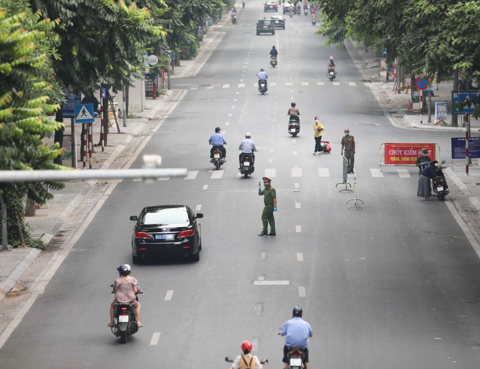  Lực lượng chốt kiểm soát phòng chống dịch trên phố Huế (quận Hai Bà Trưng) kiểm tra giấy tờ, thông tin của người lưu thông trên phố. (Ảnh: Thanh Tùng/TTXVN)