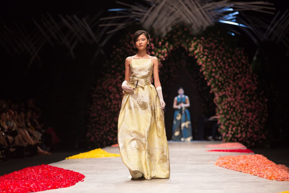 Tùy vào từng thời điểm và ánh sáng mà motif dệt trên bề mặt vải được hiệu chỉnh huyền ảo với hai sắc độ cơ bản là nhũ vàng và nhũ bạc. (Ảnh: Trí Nguyễn)