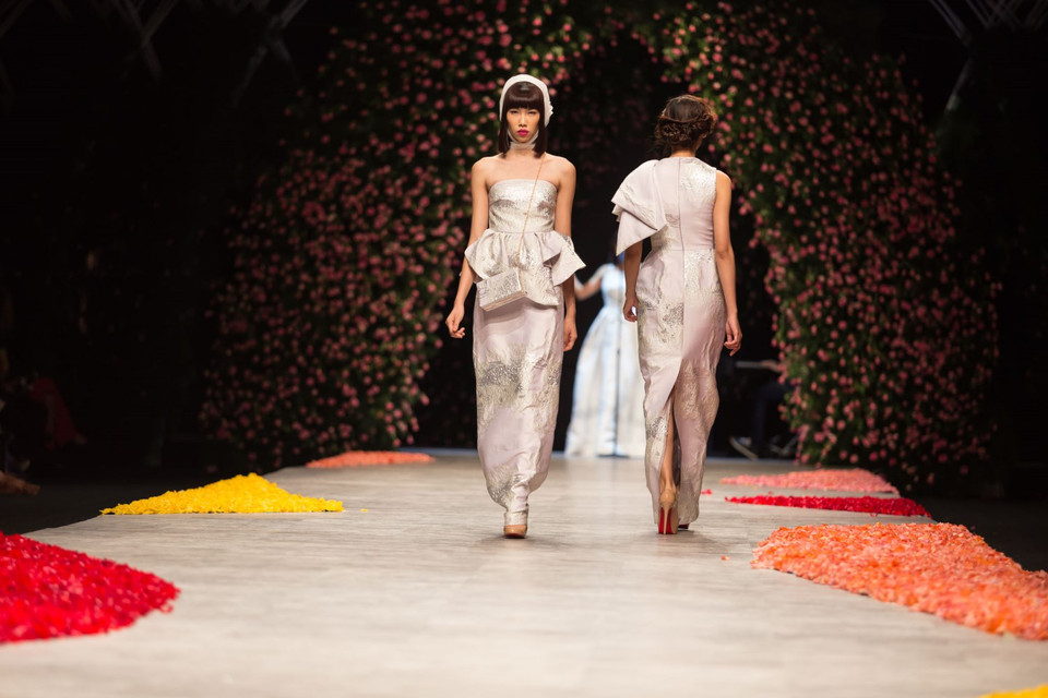 Bố cục thiết kế bất đối xứng lạ mắt đa số được xử lý với phần vải trang trí được may một bên hông hoặc vai. (Ảnh: Trí Nguyễn)