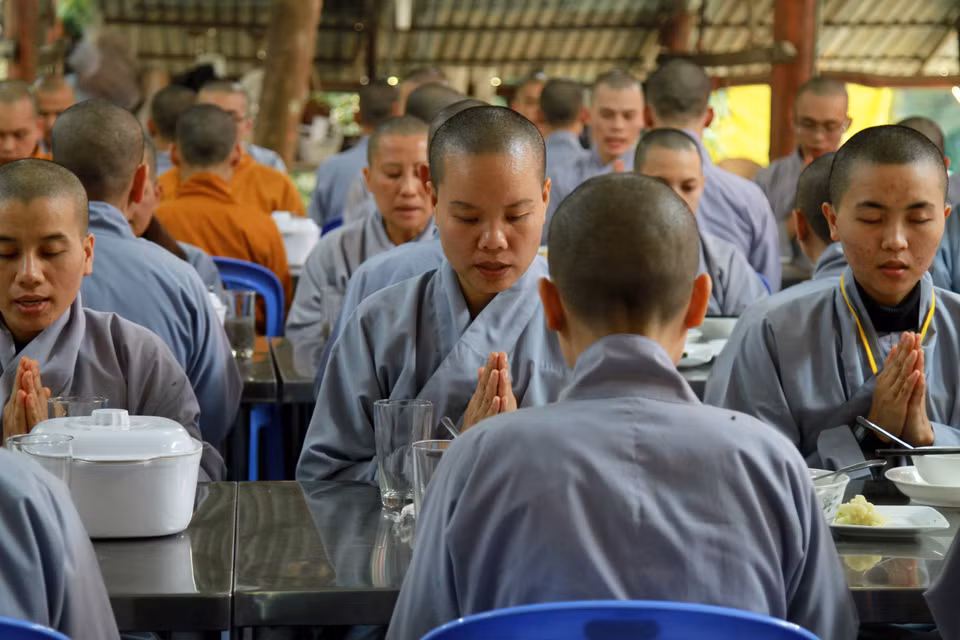 Đại chúng tề tựu, ngồi thẳng chắp tay tụng bài tán hương. (Ảnh: Xuân Mai/Vietnam+)