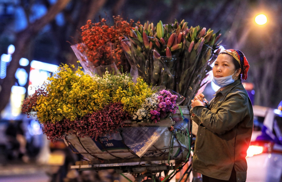 Một người bán hoa rong trên phố Phan Đình Phùng với xe hoa còn nguyên. (Ảnh: Thành Đạt/TTXVN)