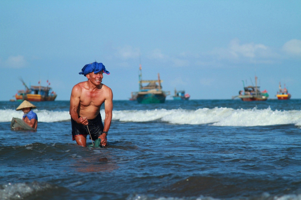 Theo ông Nương, ruốc di chuyển thành từng luồng dày đặc (cách bờ biển khoảng vài chục mét), khiến nhiều lúc nhìn mặt nước như ửng đỏ. Lợi dụng tập tính di chuyển này của ruốc, ngư dân dùng mức kéo ngược chiều để bắt. (Ảnh: Xuân Mai/Vietnam+)