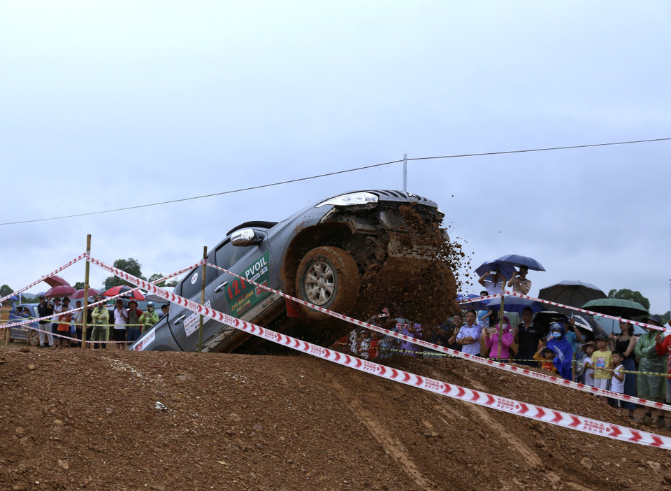 Nền đường ướt khiến một xe đua khó khăn vượt qua chướng ngại dốc cao. (Ảnh: Hoàng Hiếu/TTXVN)