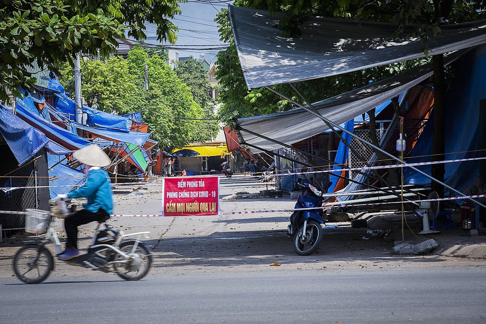 Các lực lượng chức năng thành phố Hòa Bình thực hiện bảo vệ tại các điểm ra vào khu vực phong tỏa chợ Nghĩa Phương. (Ảnh: Trọng Đạt/TTXVN)