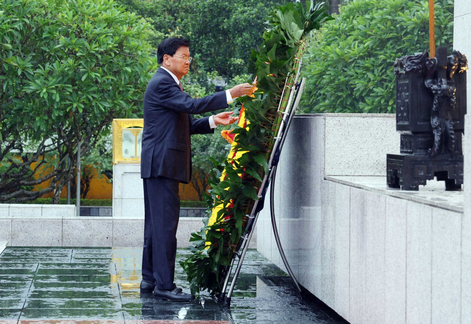 Tổng Bí thư, Chủ tịch nước Lào Thongloun Sisoulith cùng Phu nhân đến đặt vòng hoa tưởng niệm các Anh hùng liệt sỹ tại Ðài tưởng niệm các Anh hùng liệt sỹ. (Ảnh: Phạm Kiên/TTXVN)