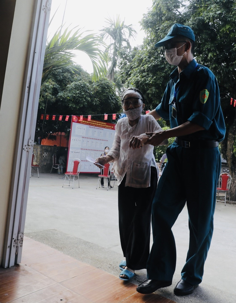 Các cử tri cao tuổi được giúp đỡ khi đi bầu cử tại điểm bầu cử xã Tự Nhiên, huyện Thường Tín, Hà Nội. (Ảnh: Trần Việt/TTXVN)