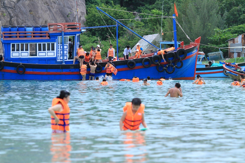 Tàu đưa du khách cập bãi Nhà Cũ lặn ngắm san hô. (Ảnh: Xuân Mai/Vietnam+)