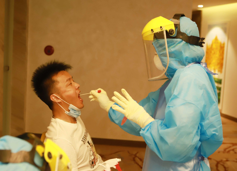 Nhân viên y tế lấy mẫu dịch hầu họng lao động nước ngoài để xét nghiệm tìm virus SARS-CoV-2 tại Khách sạn DIC STAR thành phố Vĩnh Yên, Vĩnh Phúc. (Ảnh: Hoàng Hùng/TTXVN)