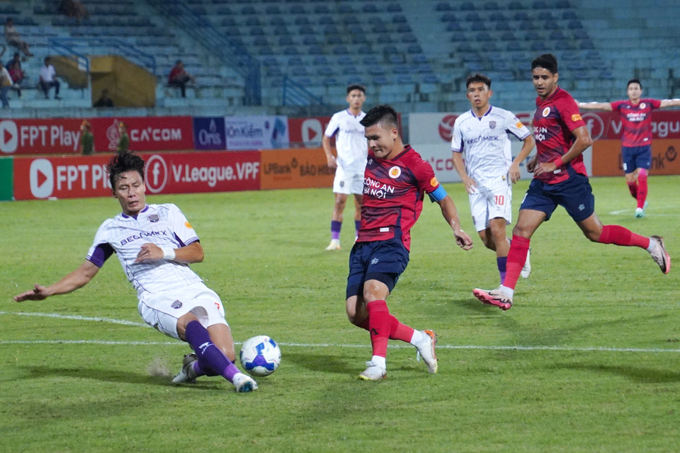 Quang Hải (áo đỏ) đánh bại người đồng đội trong màu áo Đội tuyển Quốc gia là trung vệ Quế Ngọc Hải. (Ảnh: Việt Anh/Vietnam+)