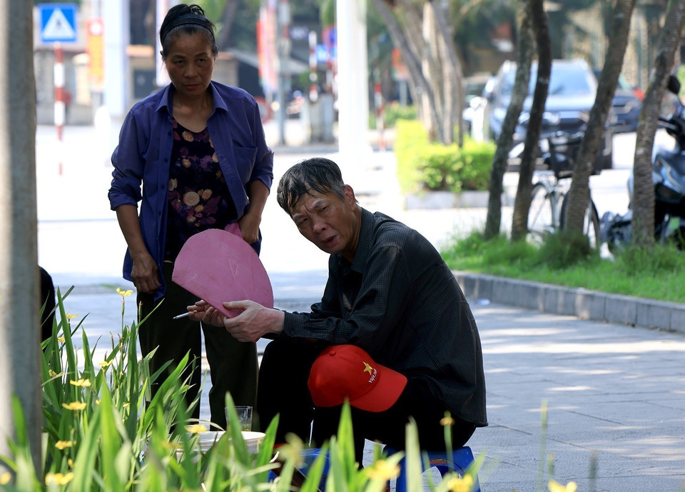 Một lái xe xích lô du lịch tranh thủ nghỉ ngơi uống nước sau những cuốc xe chở khách. (Ảnh: Tuấn Anh/TTXVN)