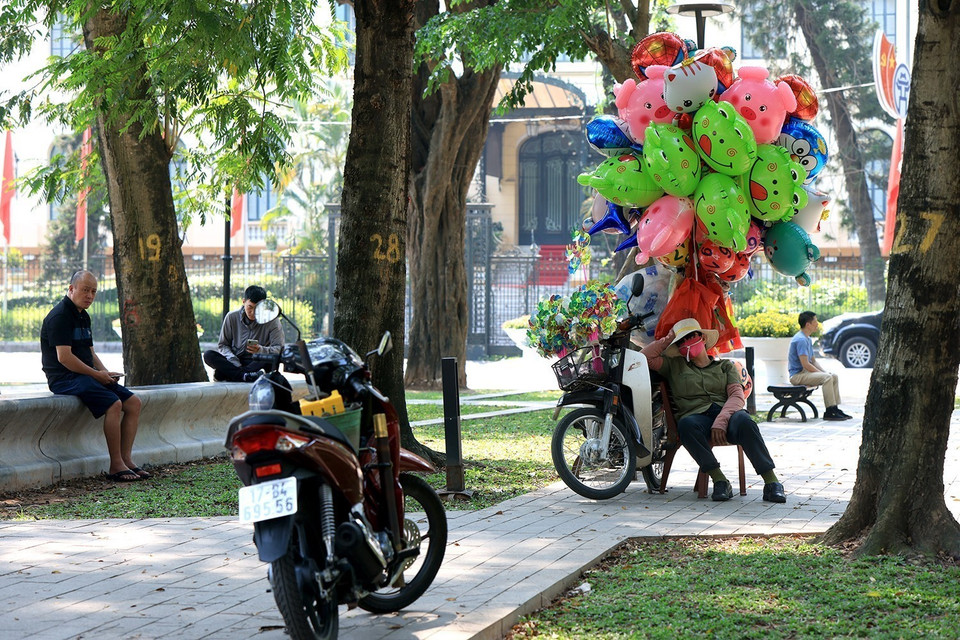 Những người bán hàng rong tranh thủ nghỉ ngơi trong các công viên, vườn hoa hay bất kỳ chỗ nào có bóng mát. (Ảnh: Tuấn Anh/TTXVN)