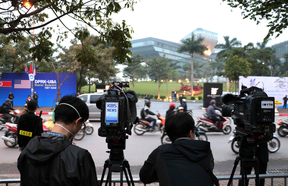 Phóng viên quốc tế tác nghiệp trên đường Đỗ Đức Dục (Từ Liêm, Hà Nội), bên ngoài khách sạn Marriott JW. (Ảnh: Văn Điệp/TTXVN)