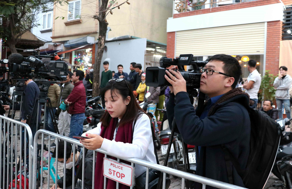 Phóng viên truyền hình Thông tấn xã Việt Nam tác nghiệp trên đường Đỗ Đức Dục (Từ Liêm, Hà Nội), bên ngoài khách sạn Marriott JW. (Ảnh: Văn Điệp/TTXVN)