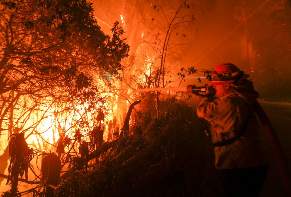 Nhân viên cứu hỏa nỗ lực khống chế các đám cháy rừng ở Malibu, California. (Ảnh: THX/TTXVN)