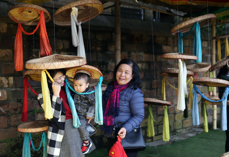  Du khách thích thú đội thử nón quai thao. (Ảnh: Danh Lam/TTXVN)