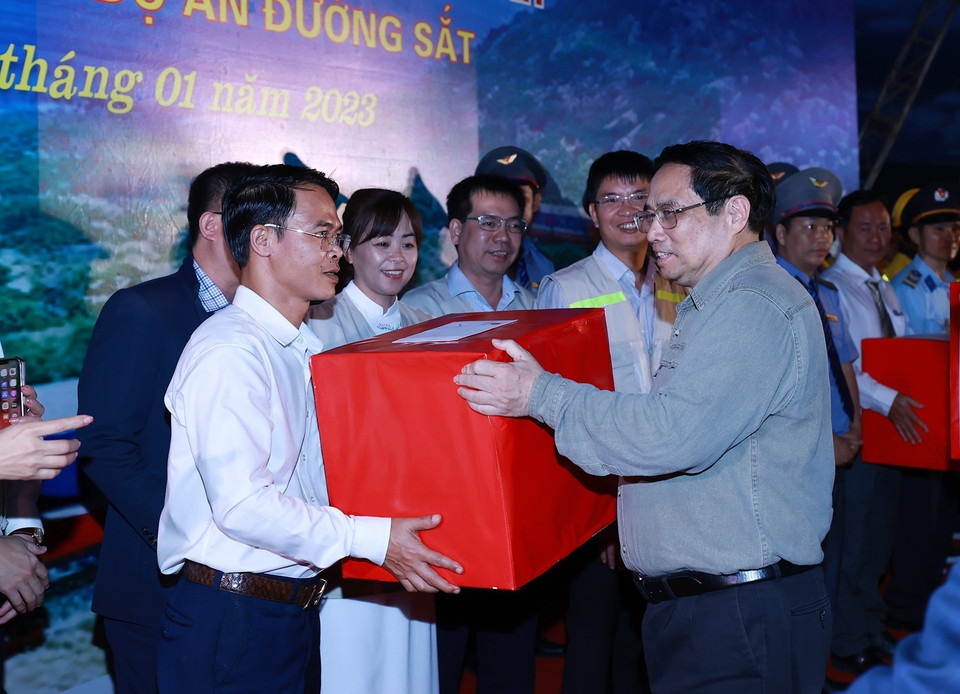 Thủ tướng Phạm Minh Chính tặng quà cho cán bộ, kỹ sư, công nhân viên tham gia dự án. (Ảnh: Dương Giang/TTXVN)