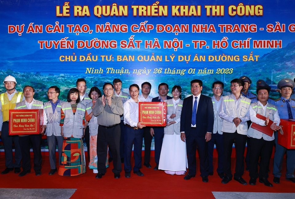 Thủ tướng Phạm Minh Chính tặng quà cho cán bộ, kỹ sư, công nhân viên tham gia dự án. (Ảnh: Dương Giang/TTXVN)