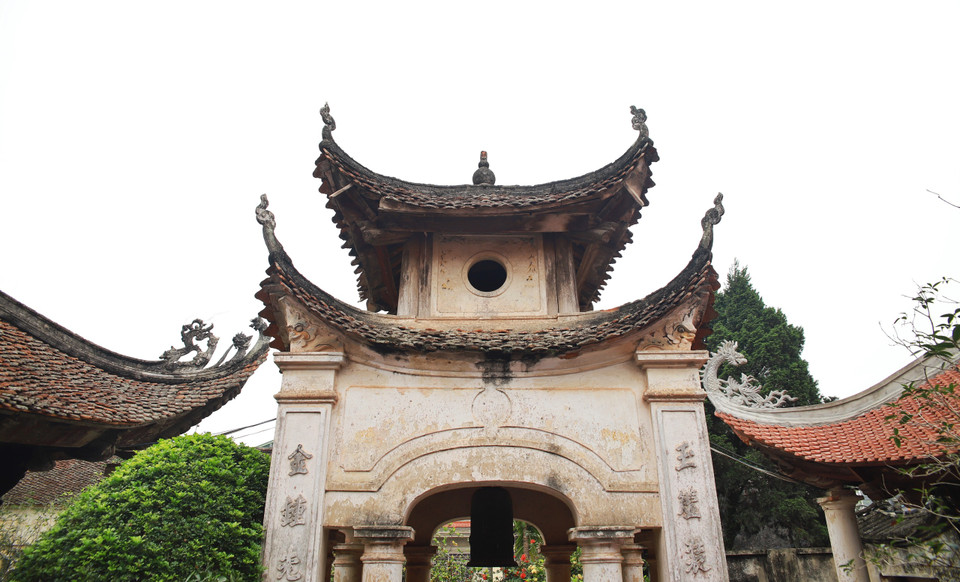 Trong khuôn viên đình, nhiều vị trí có các bia đá, chuông cổ với niên đại hàng trăm năm. Tòa đại đình là công trình lớn nhất trong khuôn viên, kiến trúc thời Lê gần như được lưu giữ nguyên vẹn với 4 mái rộng cao, 4 góc đao cong vút. Nóc đình đắp lưỡng long chầu nguyệt. (Ảnh: Công Nam/Vietnam+)