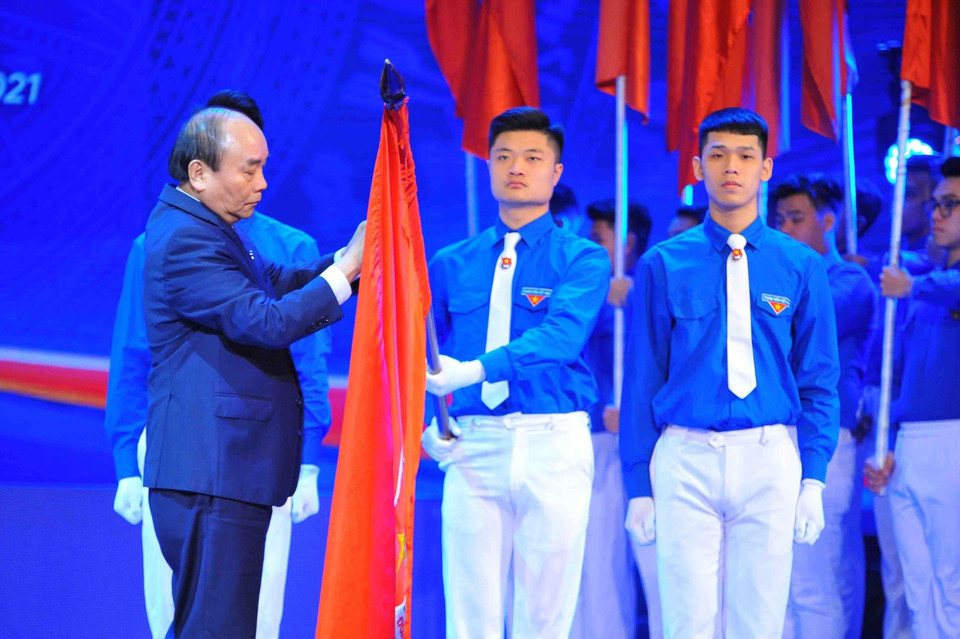 Thủ tướng Nguyễn Xuân Phúc, Chủ tịch Hội đồng Thi đua- Khen thưởng Trung ương, gắn Huân chương Hồ Chí Minh lên cờ truyền thống của Trung ương Đoàn Thanh niên Cộng sản Hồ Chí Minh. (Ảnh: Minh Đức/TTXVN)