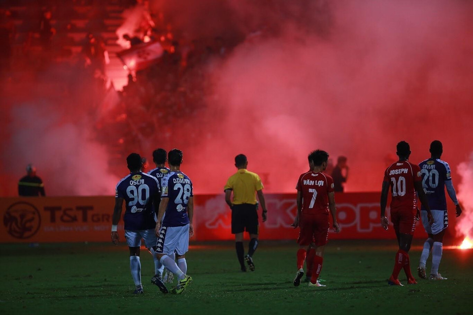 Tối 21/4, trên sân Hàng Đẫy, đội chủ nhà Hà Nội FC (áo tím) gặp đội Hải Phòng (áo đỏ) trong trận đấu ở vòng 6 Giải bóng đá vô địch quốc gia Wake up 247-V.League 2019. Khói mù mịt sân Hàng Đẫy do cổ động viên Hải Phòng đốt pháo sáng trên khán đài, khiến trọng tài phải thổi còi gián đoạn trận đấu ít phút. (Ảnh: Trọng Đạt/TTXVN)