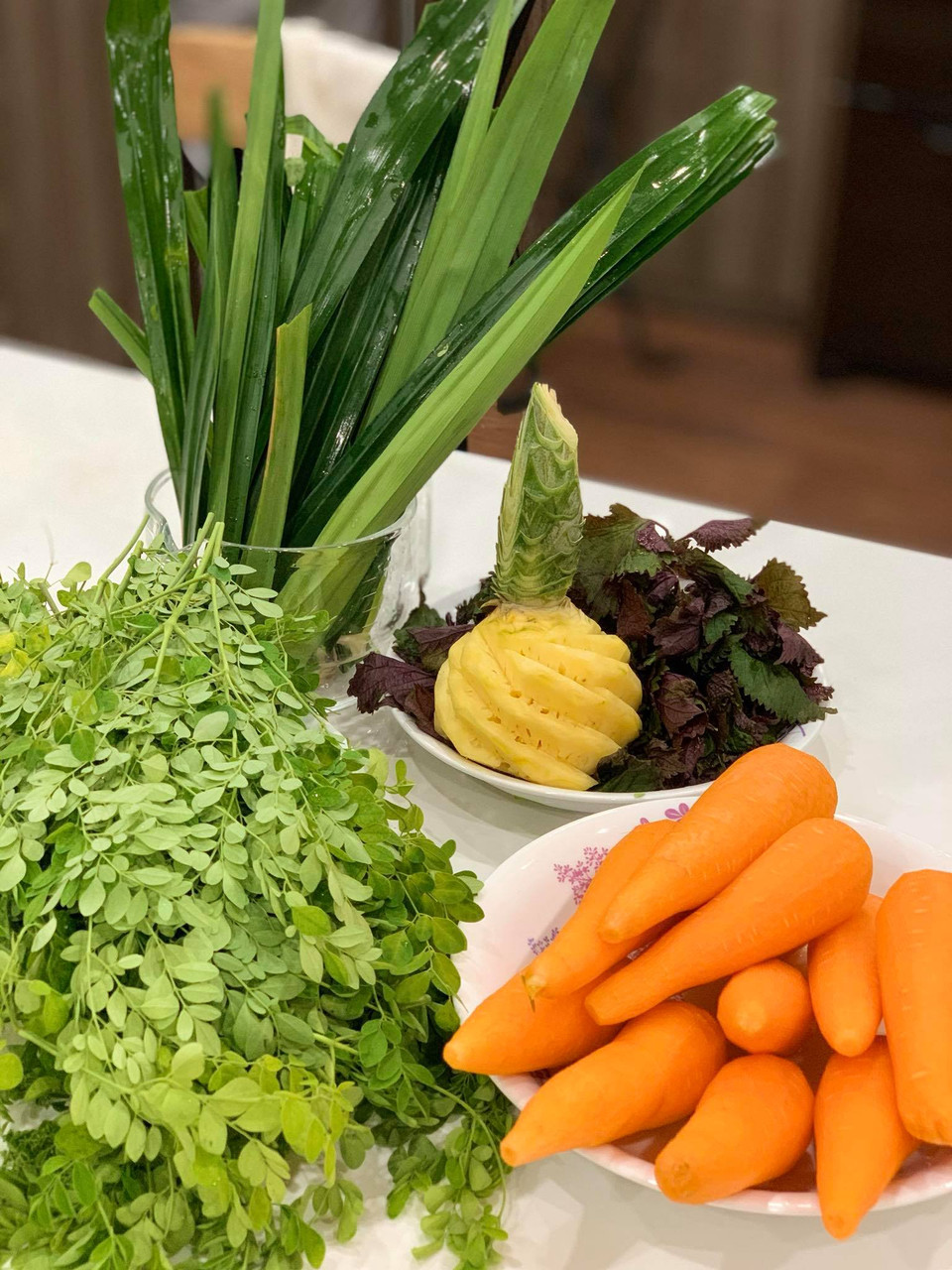 Vì chùm ngây và tía tô đều có dược tính cao nên sẽ có vị nồng mạnh, cần thêm 70% nguyên liệu là những chất nền để làm vị nước ép dịu ngọt bớt như cà rốt, dứa, cây lá nếp. (Ảnh: Đậu Đậu/Vietnam+)