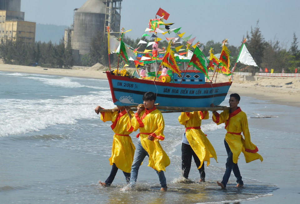 Nhân dân tại khu dân cư văn hóa biển Kim Liên làm lễ rước, thả thuyền. Ảnh: Đinh Văn Nhiều/TTXVN)