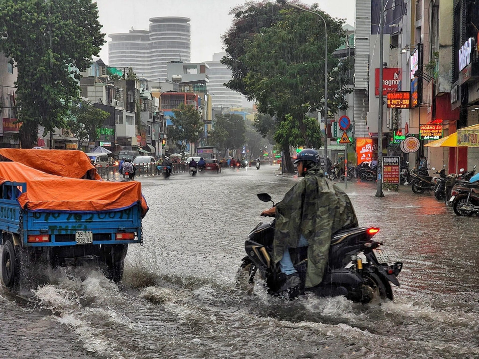 Các phương tiện di chuyển khó khăn giữa dòng nước. (Ảnh: Hồng Giang/TTXVN)