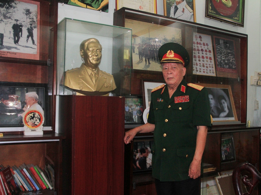 Trung tướng Lê Nam Phong bên bức tượng ông bằng thạch cao do Bảo tàng Quân khu 7 tặng. (Ảnh: ChiLê/vietnam+)
