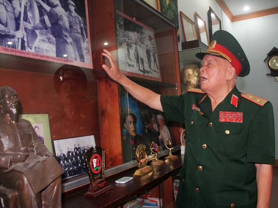 Trung tướng Lê Nam Phong kể lại lịch sử chiến dịch Điện Biên Phủ qua ảnh tại tư gia. (Ảnh: ChiLê/Vietnam+)