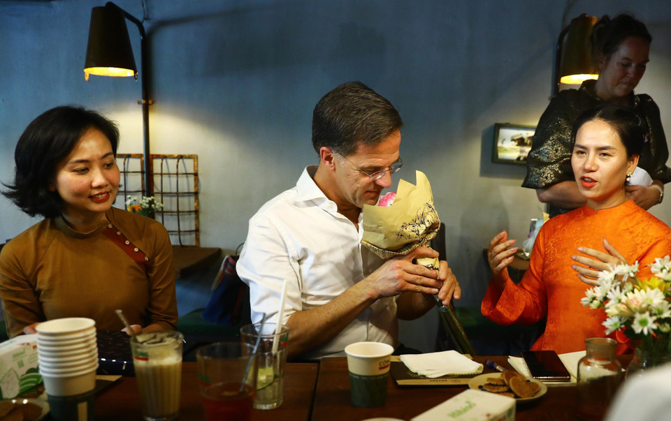 Được tặng hoa sen, Thủ tướng Vương quốc Hà Lan Mark Rutte bảy tỏ thích thú với quốc hoa của Việt Nam. (Ảnh: Lâm Khánh/TTXVN)