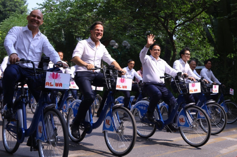 Thủ tướng Phạm Minh Chính cùng Thủ tướng Hà Lan Mark Rutte đạp xe trên đường phố Hà Nội. (Ảnh: Văn Điệp/TTXVN)