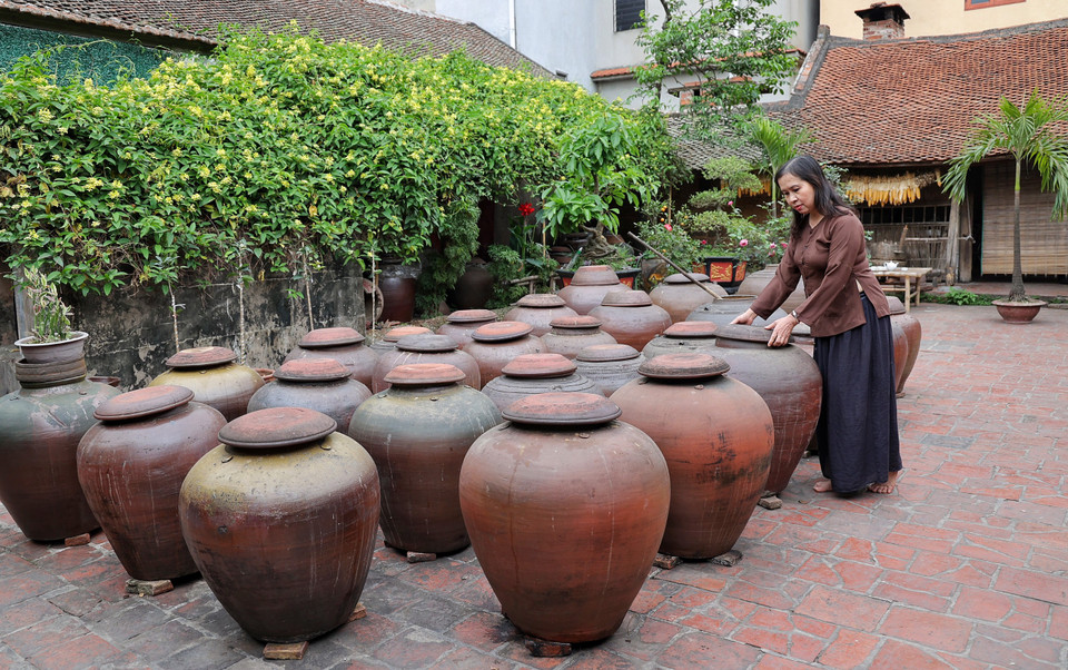 Mỗi chum tương cả trăm lít ủ càng lâu càng thơm ngon, đã trở thành món quà không thể thiếu với mỗi du khách sau mỗi chuyến ghé thăm Đường Lâm. (Ảnh: Xuân Mai/Vietnam+)